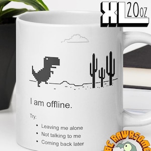 May include: White ceramic mug with a black and white illustration of the classic offline dinosaur game. The mug reads "I am offline. Try: Leaving me alone, Not talking to me, Coming back later." The mug is 20 ounces.