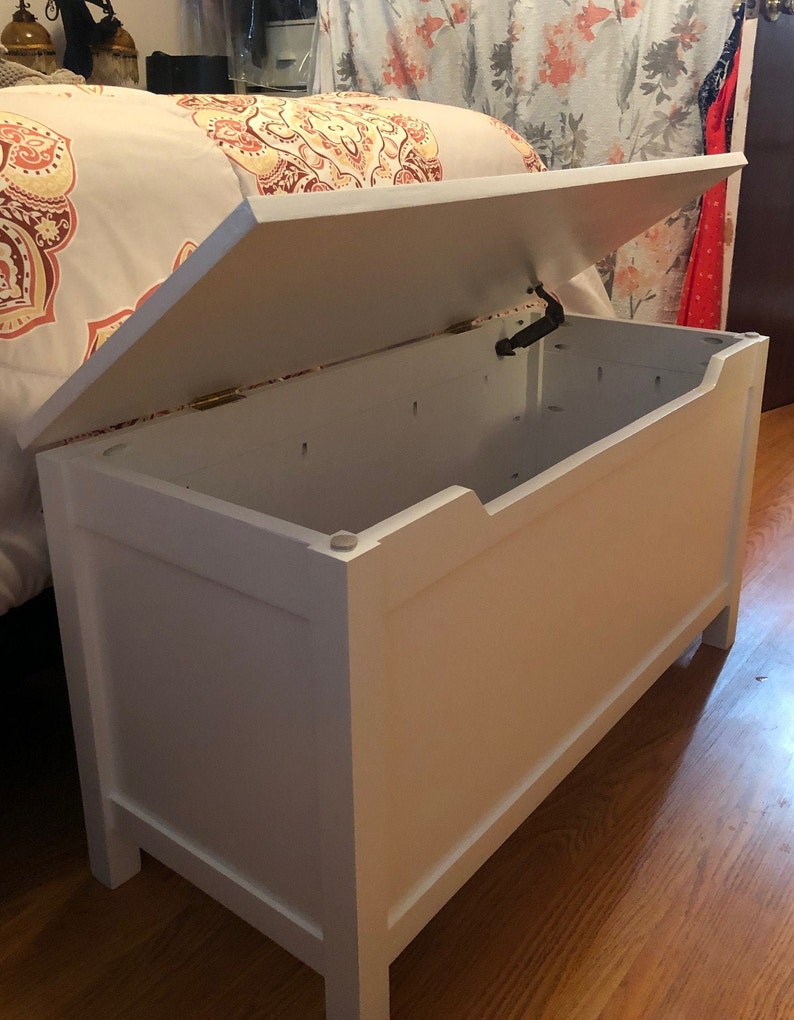 May include: White wooden storage chest with a hinged lid. The lid is open and the chest is empty.