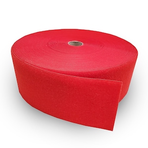 May include: A roll of red hook and loop tape. The tape is rolled up and the end is unfurled, showing the soft, fuzzy texture.