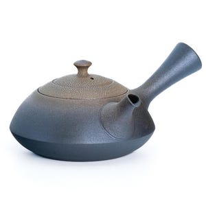 May include: A ceramic teapot with a dark blue and brown gradient finish. The teapot has a side handle and a small spout. The lid is brown with a small knob. The teapot is designed for tea brewing.