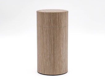 May include: A cylindrical wooden tea canister with a light brown wood grain finish.