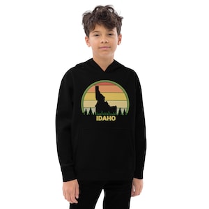 May include: Black hooded sweatshirt with a vintage-style graphic of the state of Idaho in front of a sunset. The graphic includes the text "IDAHO" in yellow.