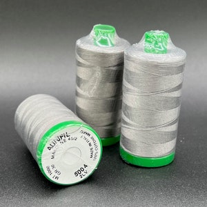 May include: Three spools of gray thread with green labels. The labels read "100% cotone Mako", "Made in Italy", "Mako NE 40/2", "5004 2LV", "GR 30", and "MT 1000".