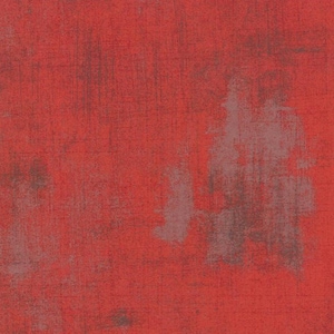 May include: Red textured fabric with a faded, distressed look. The fabric has a subtle pattern of light and dark red hues.