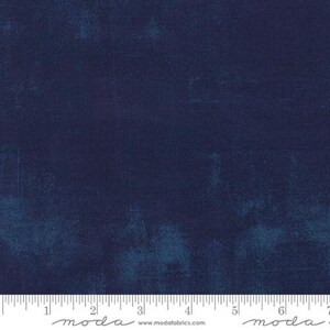 May include: A solid navy blue fabric with a subtle textured pattern. The fabric is shown with a ruler measuring 7 inches.