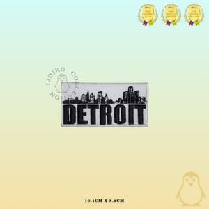 Puede incluir: Parche blanco bordado con una silueta de ciudad negra y la palabra "DETROIT" en letras negras. El parche mide 10,1 cm por 5,2 cm.