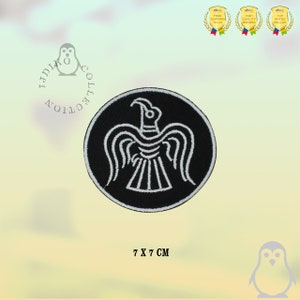 Könnte beinhalten: Schwarz-weiß gestickter Aufnäher mit einem stilisierten Raben auf einem runden schwarzen Hintergrund. Der Aufnäher misst 7 x 7 Zentimeter.