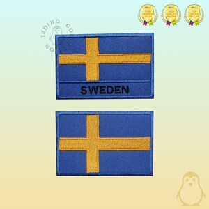 May include: Two embroidered patches featuring the Swedish flag. The top patch has the word "SWEDEN" written below the flag. Both patches are blue with a yellow cross.