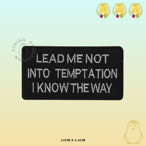May include: Black embroidered patch with white text that reads "Lead me not into temptation I know the way". The patch is 10 cm by 5.3 cm.