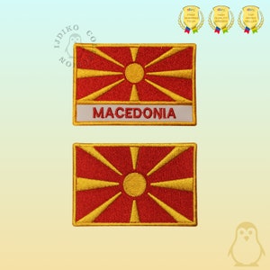 May include: Two embroidered patches featuring the flag of North Macedonia. The top patch has the words "MACEDONIA" written in white on a gold background. Both patches have a red background with a yellow sun and eight rays.