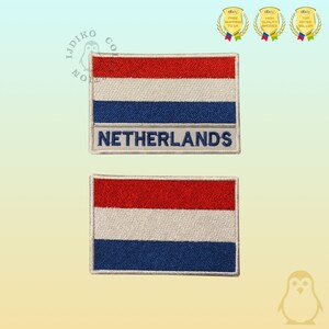 Peut inclure: Deux patchs brodés représentant le drapeau néerlandais. Le patch du haut porte le mot "PAYS-BAS" sous le drapeau. Les deux patchs sont blancs avec des coutures rouges, blanches et bleues.
