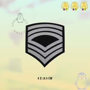 May include: A silver and black embroidered patch with five chevrons, measuring 9 by 12.5 centimetres.