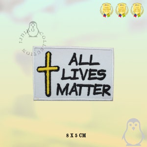 May include: White embroidered patch with a yellow cross and the text "ALL LIVES MATTER" in black lettering. The patch measures 8 by 5 centimetres.