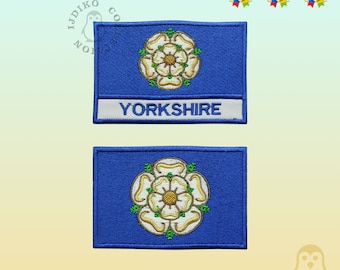 May include: Two embroidered patches featuring the white rose of Yorkshire on a blue background. The top patch has the word "YORKSHIRE" written in white on a white background.