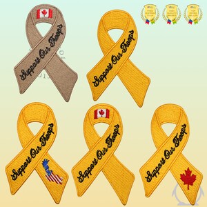 Pode incluir: Cinco patches bordados de fita amarela com o texto "Support Our Troops" e diferentes designs de bandeiras. As bandeiras incluem a bandeira canadiana, a bandeira americana e uma folha de bordo vermelha.