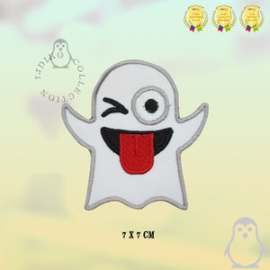 Op de afbeelding: Witte ghost emoji strijk-op-patch met een knipperend oog, een brede glimlach en een rode tong die uitsteekt. De patch is 7 cm bij 7 cm.