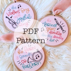 May include: Three embroidered hoops with musical instrument designs and text. The text includes "the Violins sing with joyful Ring", "the clarinet goes doodly doodly det", and "the horn it sounds so forlorn". The text "PDF Pattern" is also present.