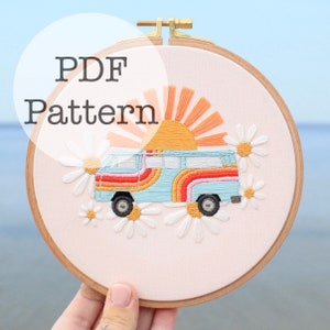Op de afbeelding: Een PDF-patroon voor een kleurrijk borduurproject in een borduurring met een vintage busje met regenboogstrepen, een zon en madeliefjes. Het patroon heeft de titel "PDF Pattern".