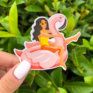 May include: A pink flamingo pool float with a woman wearing sunglasses and a yellow swimsuit riding on top.