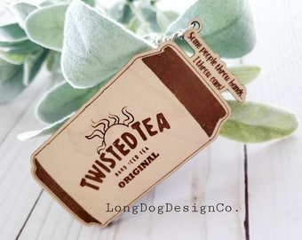 May include: Wooden keychain shaped like a Twisted Tea can with the text "Some people throw hands I throw cans!" and "Twisted Tea Hard Iced Tea Original" and "Long Dog DesignCo."