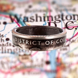 May include: A silver ring made from a quarter with the inscription "DISTRICT OF COLUMBIA" on the band.