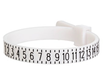 May include: White plastic ring sizer with black numbers from 1 to 15.