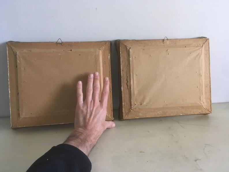 Op de afbeelding: Twee bruine fotolijsten met gouden rand en ophanghaken. De lijsten zijn leeg en hebben een getextureerd oppervlak.