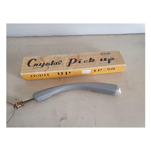 May include: A grey crystal pick-up for a record player. The box reads "Crystal Pick Up Model UP - LP 78" and "Piezo".
