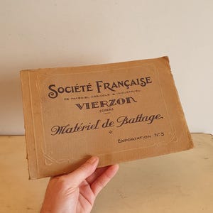 May include: A vintage brown paper booklet with the title "SOCIÉTÉ FRANÇAISE DE MATÉRIEL AGRICOLE & INDUSTRIEL VIERZON (CHER) Matériel de Battage EXPORTATION N°3"