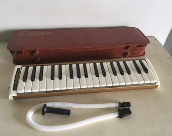 Jahrgang 1960 „Samick Melodihorn M-36“ Melodica. Funktionierendes, unbenutztes Tasteninstrument. Lederetui, neuwertiger Zustand.