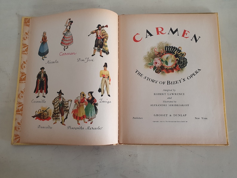 May include: An illustrated book cover for a children's adaptation of the opera Carmen by Bizet. The cover features a colorful illustration of a woman in a red dress and a man in a black and white suit. The title "Carmen" is written in large, bold letters at the top of the cover. The book is published by Grosset & Dunlap.