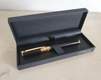 Pluma estilográfica S.T. Dupont Paris chapada en oro y negra en su caja original, sin usar, fabricada en China, elegante instrumento de escritura