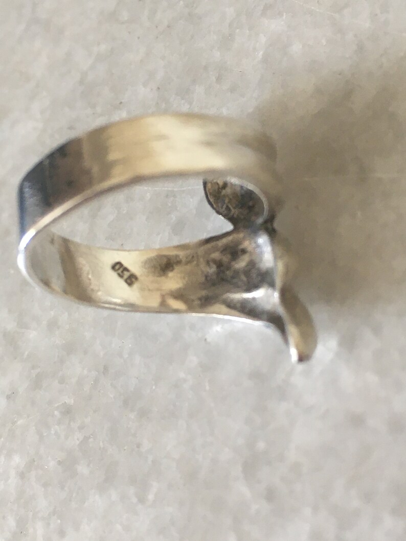 May include: Silver ring with a textured design and the number 925 stamped on the inside band.