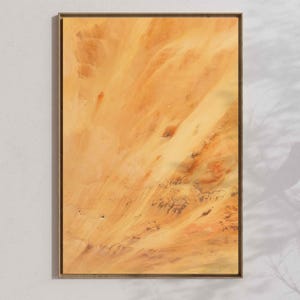 Pode incluir: Impressão de arte abstrata em uma moldura de madeira retangular. A obra apresenta uma mistura de cores quentes, incluindo tons de laranja, amarelo e marrom, criando um design texturizado e fluido. A peça é montada em uma parede branca.