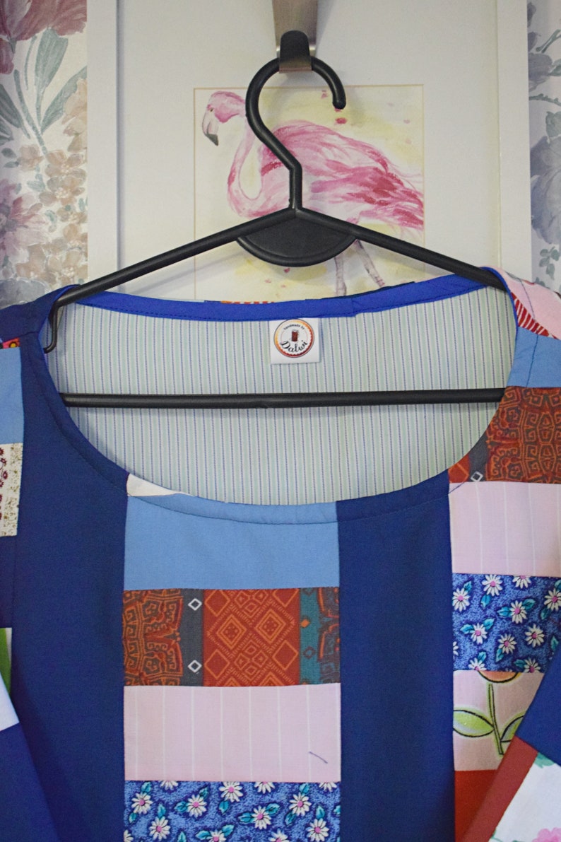 May include: A blue patchwork top with a white and green striped lining. The top has a round neckline and a label that says "Dalia's".