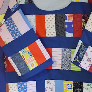 Puede incluir: Una camisa azul de patchwork con una variedad de telas coloridas cosidas juntas en un patr&oacute;n de rayas. La camisa tiene un cuello redondo y mangas largas.