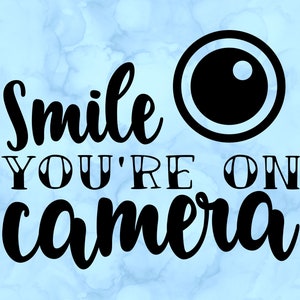 May include: Black and white graphic with the text "Smile You're On Camera" and a stylized camera lens.