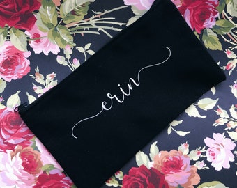 May include: Black canvas zippered pouch with the name "erin" written in white cursive script.
