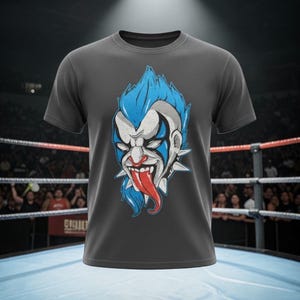 May include: Dark gray t-shirt featuring a menacing clown face with blue hair, white face paint, and a red tongue. The clown has a spiked collar. The shirt is displayed in a wrestling ring.