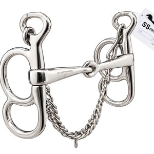 May include: A silver-coloured metal horse bit featuring a curb chain and large cheek pieces. The mouthpiece is engraved with the text SS EQUESTRIAN GEARS 5". A white rectangular tag attached to the top ring displays the logo and text SS EQUESTRIAN GEARS.