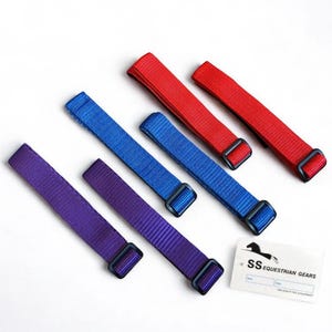 May include: An assortment of colorful nylon straps in red, blue, and purple, each with a black buckle. A white tag with the text "SS EQUESTRIAN GEARS" is also present.