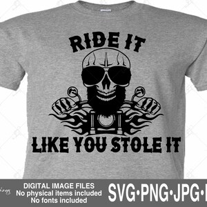May include: A gray t-shirt with a black graphic of a skull wearing sunglasses and a beard, riding a motorcycle. The text "RIDE IT LIKE YOU STOLE IT" is above and below the graphic.