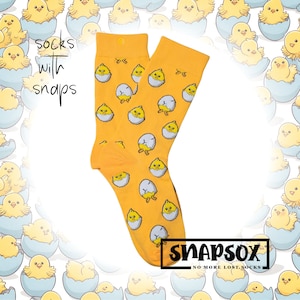 May include: A pair of yellow socks with a pattern of baby chicks hatching from eggs. The socks have the text "socks with snaps" and "Snapsox No More Lost Socks" printed on them.
