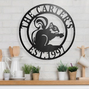 May include: Black metal sign featuring the text "The Carters Est 1991" and a silhouette of a squirrel holding a nut.