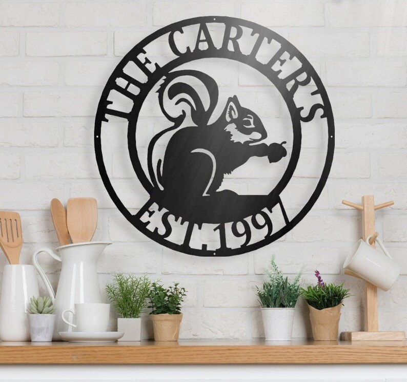 May include: Black metal sign featuring the text "The Carters Est 1991" and a silhouette of a squirrel holding a nut.