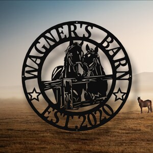 Pode incluir: Placa de metal preto com o texto "Wagner's Barn Est. 2020" em um círculo. Dois cavalos estão em silhueta no centro do círculo, olhando para o espectador.