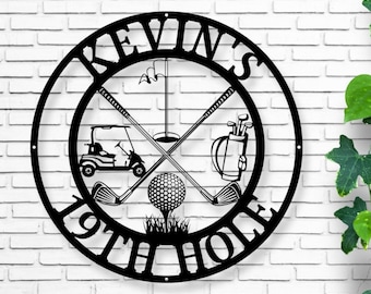 May include: Black metal golf-themed wall art with the name "KEVIN'S" and "19TH HOLE" in a circular design. Features crossed golf clubs, a golf ball on a tee, a golf cart, and a golf bag. Decorative item for golf enthusiasts.