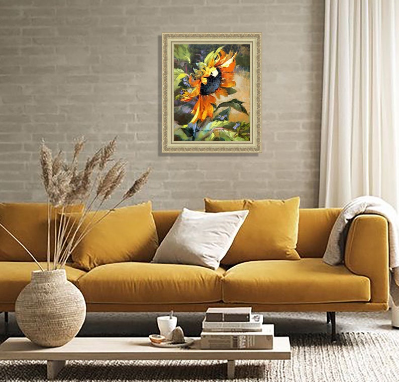 以下が含まれることがあります： オレンジと黄色の花びら、濃い茶色の芯、緑の葉を持つひまわりの絵画が額装されています。絵画は緑と茶色の背景に描かれています。