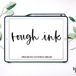 May include: A white tablet with a black frame displaying the text "rough ink" in black script. The text "Procreate lettering brush" is also displayed in black text. The tablet is on a white surface with green leaves on either side.