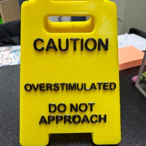 Señal de escritorio de precaución sobreestimulado